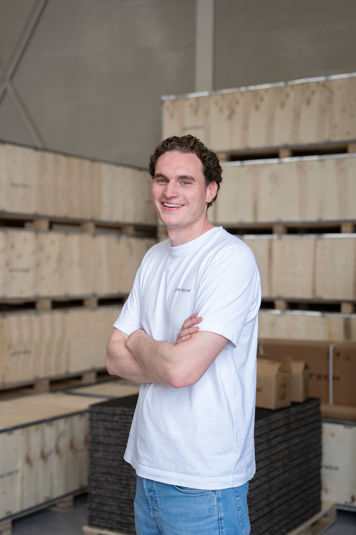 Employé de Fitnessdepot dans un t-shirt Martech blanc, dans l'entrepôt