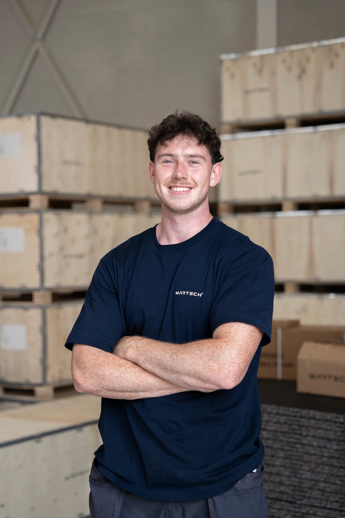 Employé de Fitnessdepot dans un t-shirt Martech bleu foncé, dans l'entrepôt
